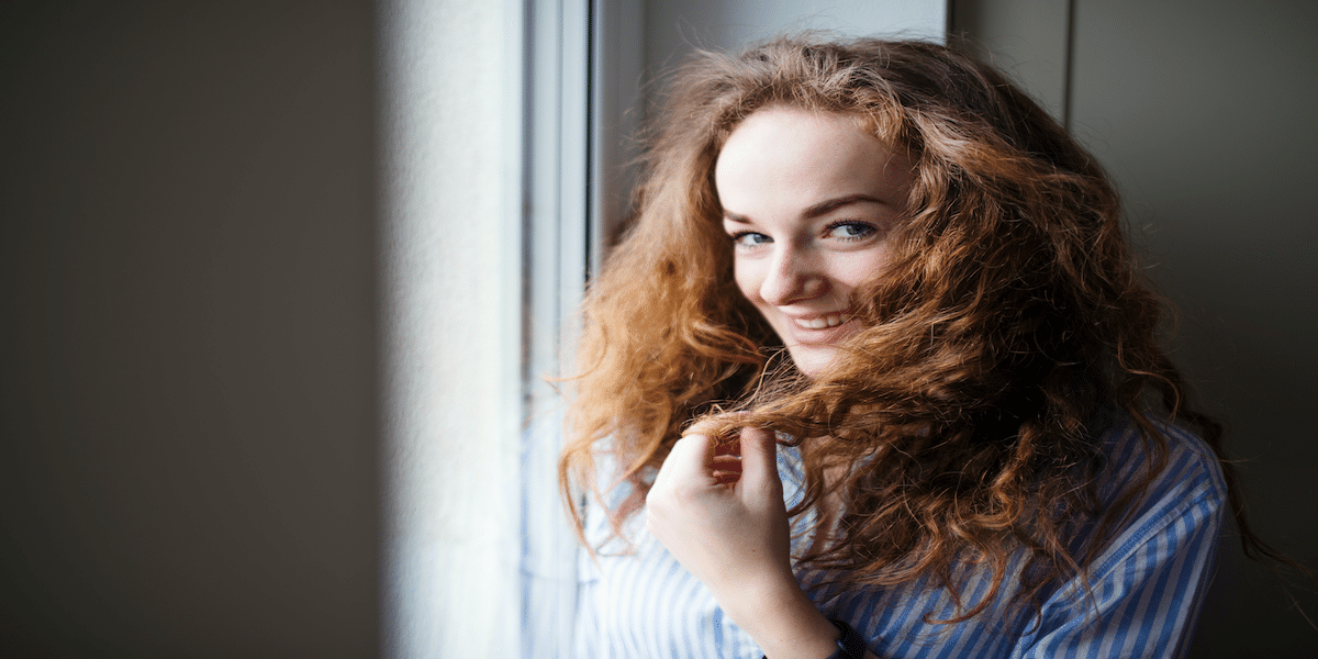 Image commercially licensed from https://unsplash.com/photos/close-up-portrait-of-young-woman-standing-by-window-indoors-at-home-copy-space-t0udzNTUbyY